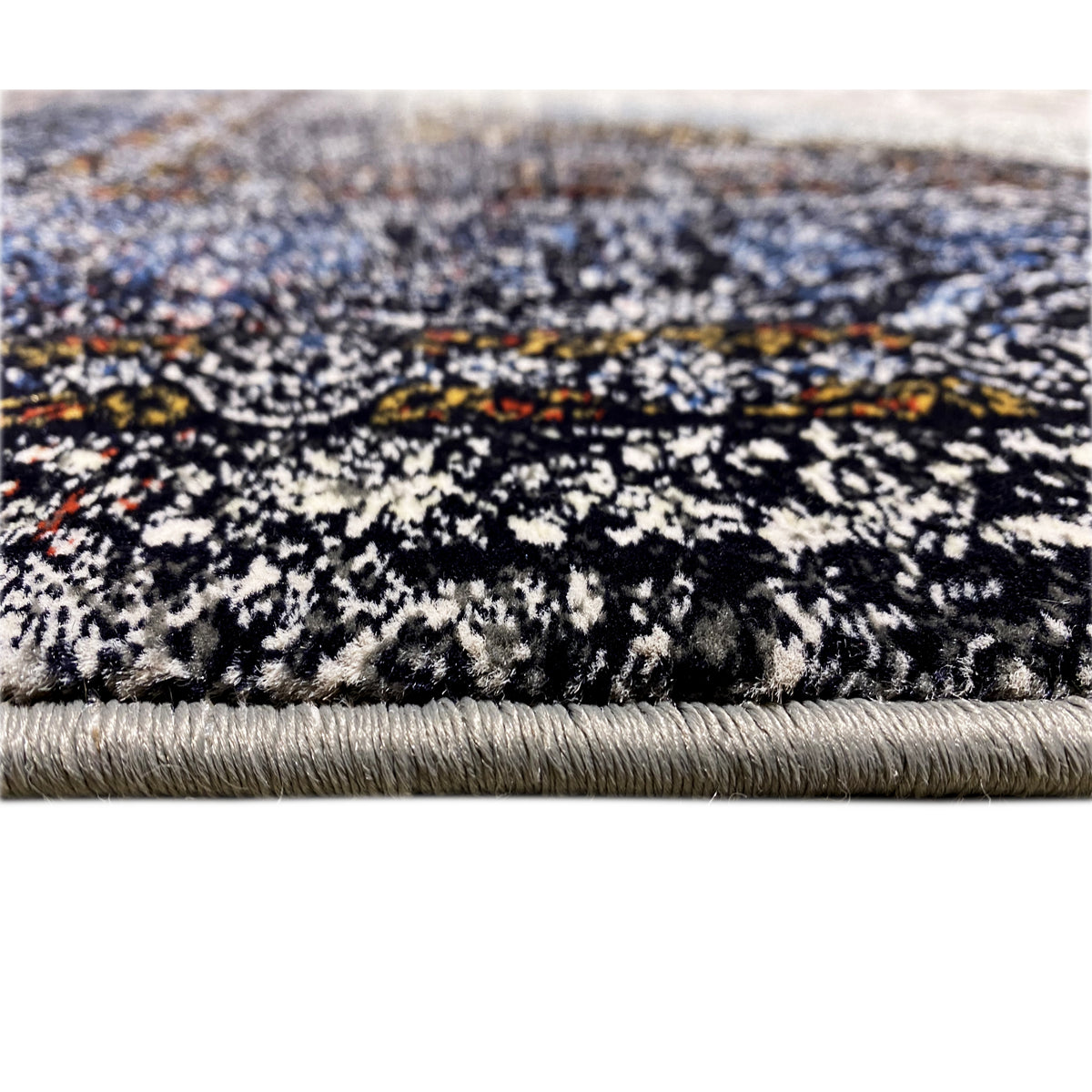 Tapis à motif chiné multicolore et franges sur le bord, dans des tons noirs et bleus