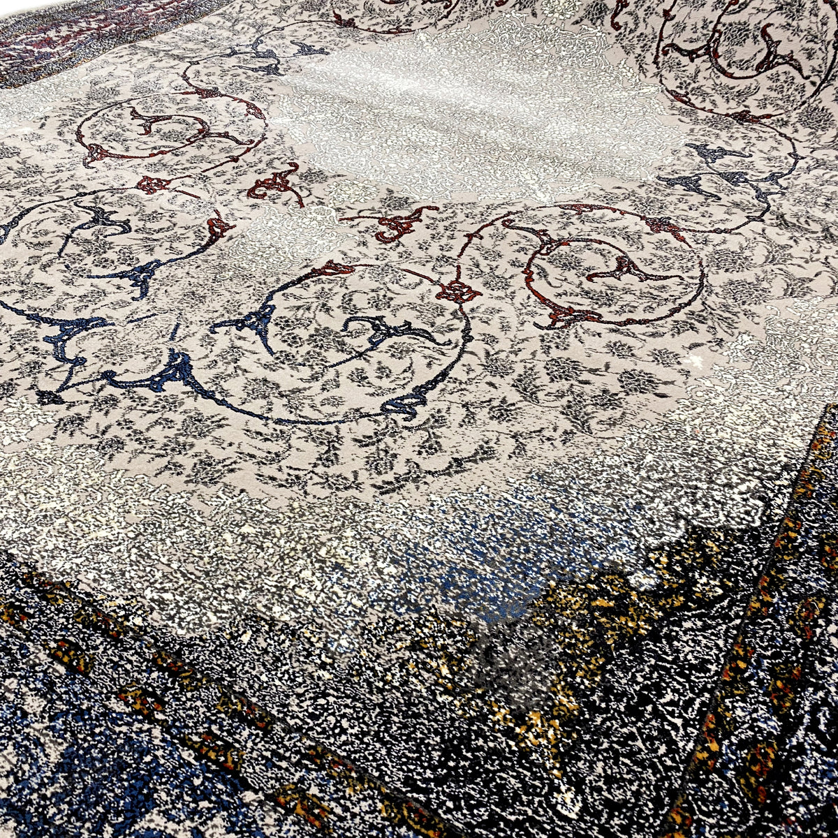 Surface de tapis ornée de motifs décoratifs gris et bleu foncé, avec des touches de jaune