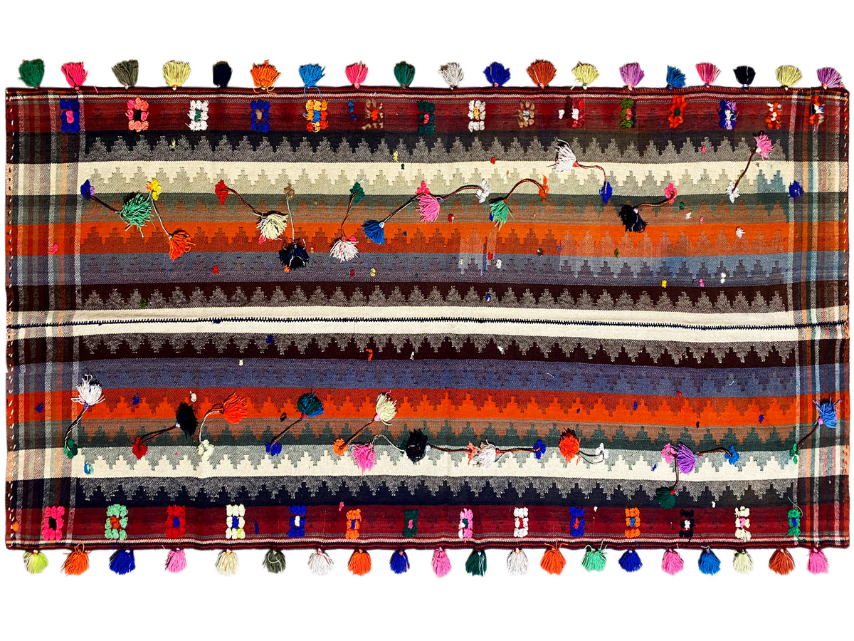 Tapis rayé multicolore à motifs floraux, bordure décorative et pompons