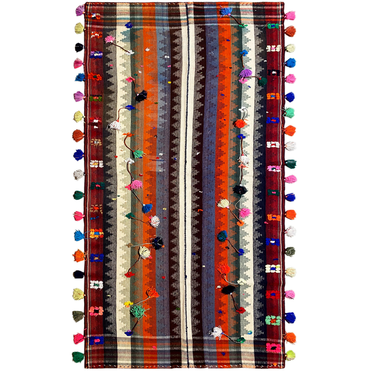 Tapis jajim coloré avec des rayures multicolores et des pompons sur les bords