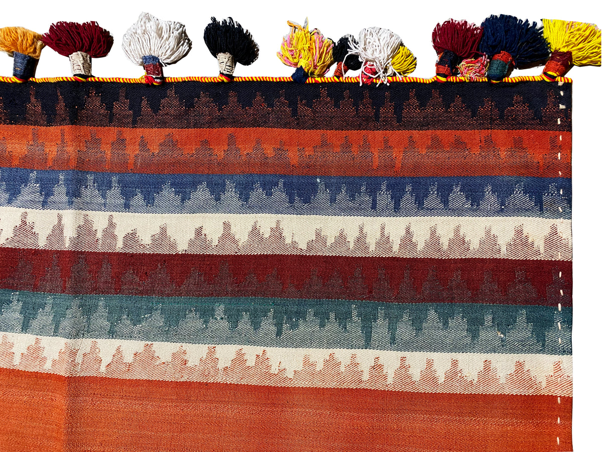Tapis jajim vu de près du dessus : rayures multicolores et franges à pompons sur le bord