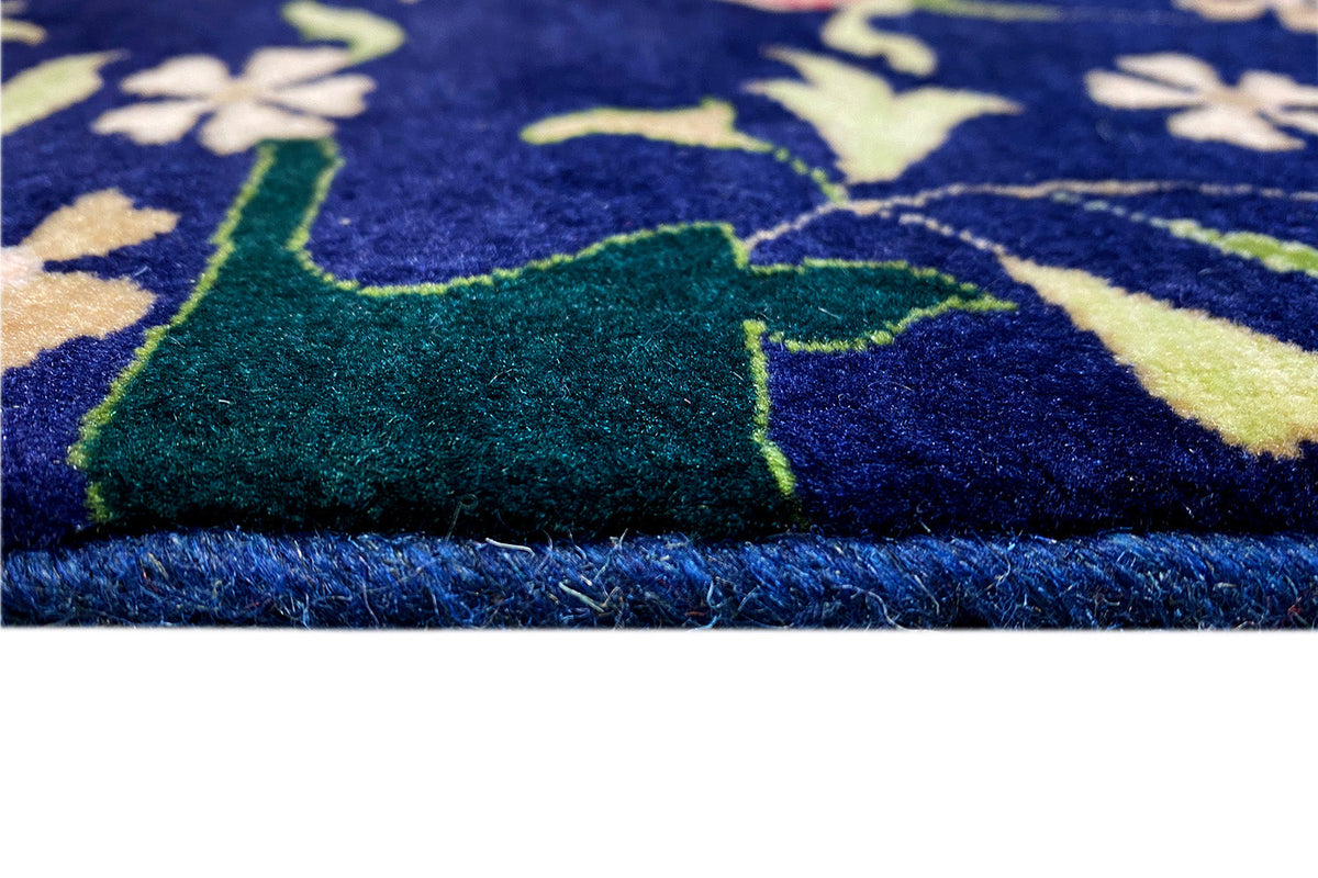 Gros plan sur les poils du tapis et les franges de bordure, motif bleu