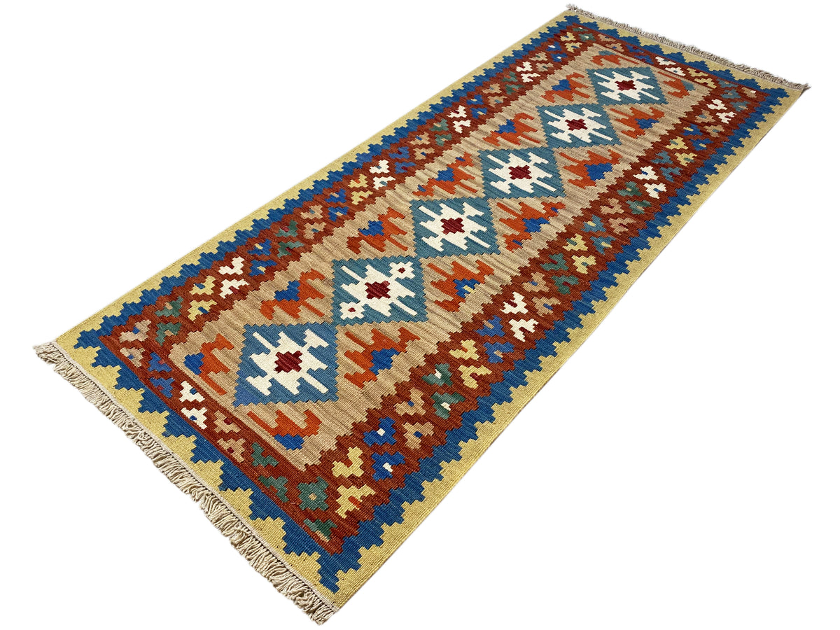 Tapis kilim avec des champs beiges, des motifs géométriques bleus, bruns et blancs