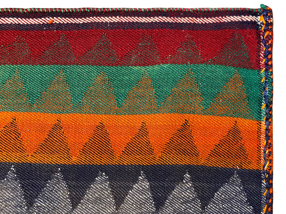 Détail du tapis kilim Jajim : rayures multicolores, motif en zigzag, bordure gansée