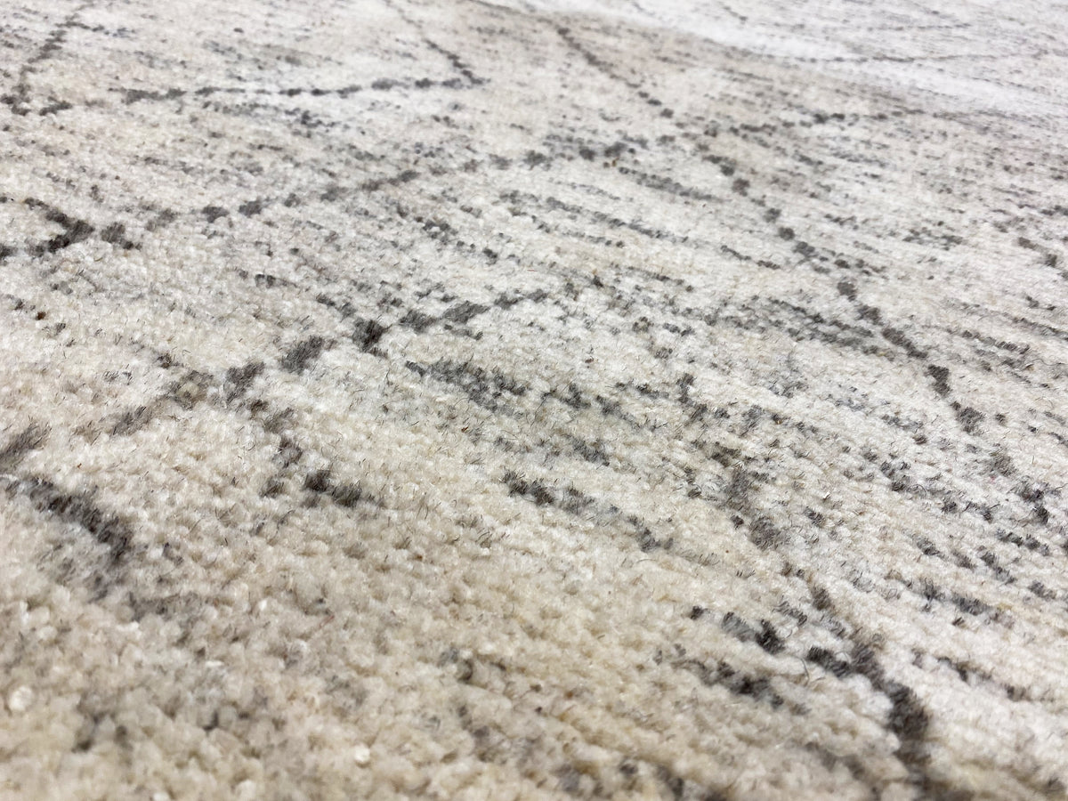 Gros plan : tapis berbère à poils chinés et motif de lignes gris foncé