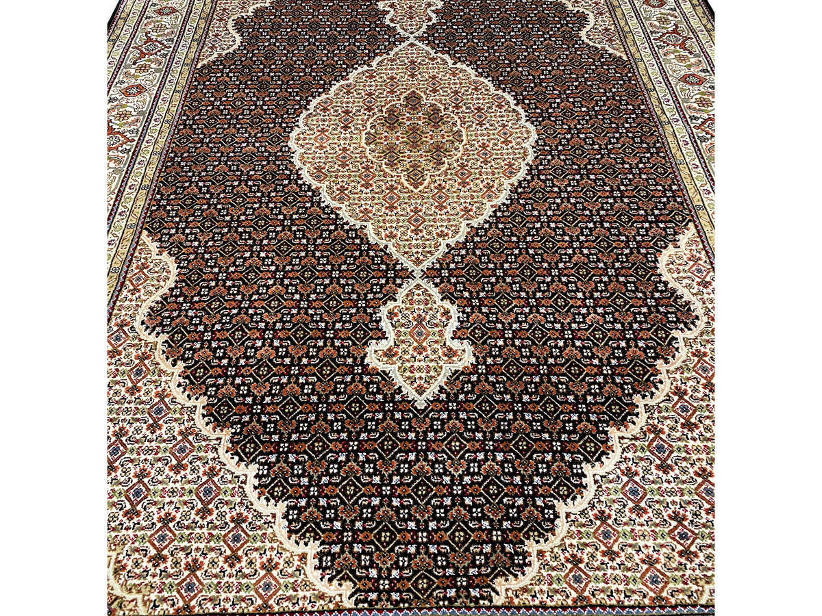 Détail du tapis indo-Tabriz brun : motif fin dans le champ sombre au centre clair