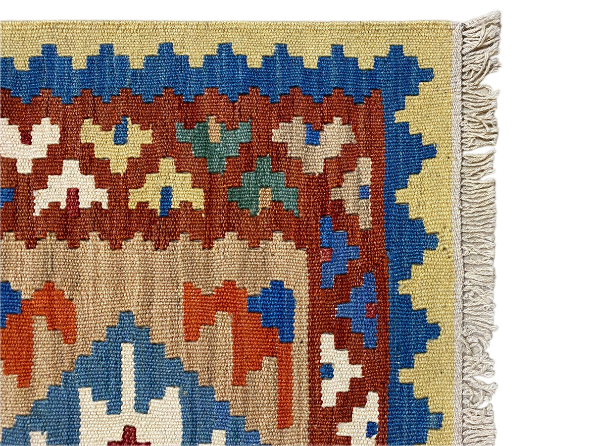 Bordure de tapis kilim à franges avec liseré bleu, ornements multicolores