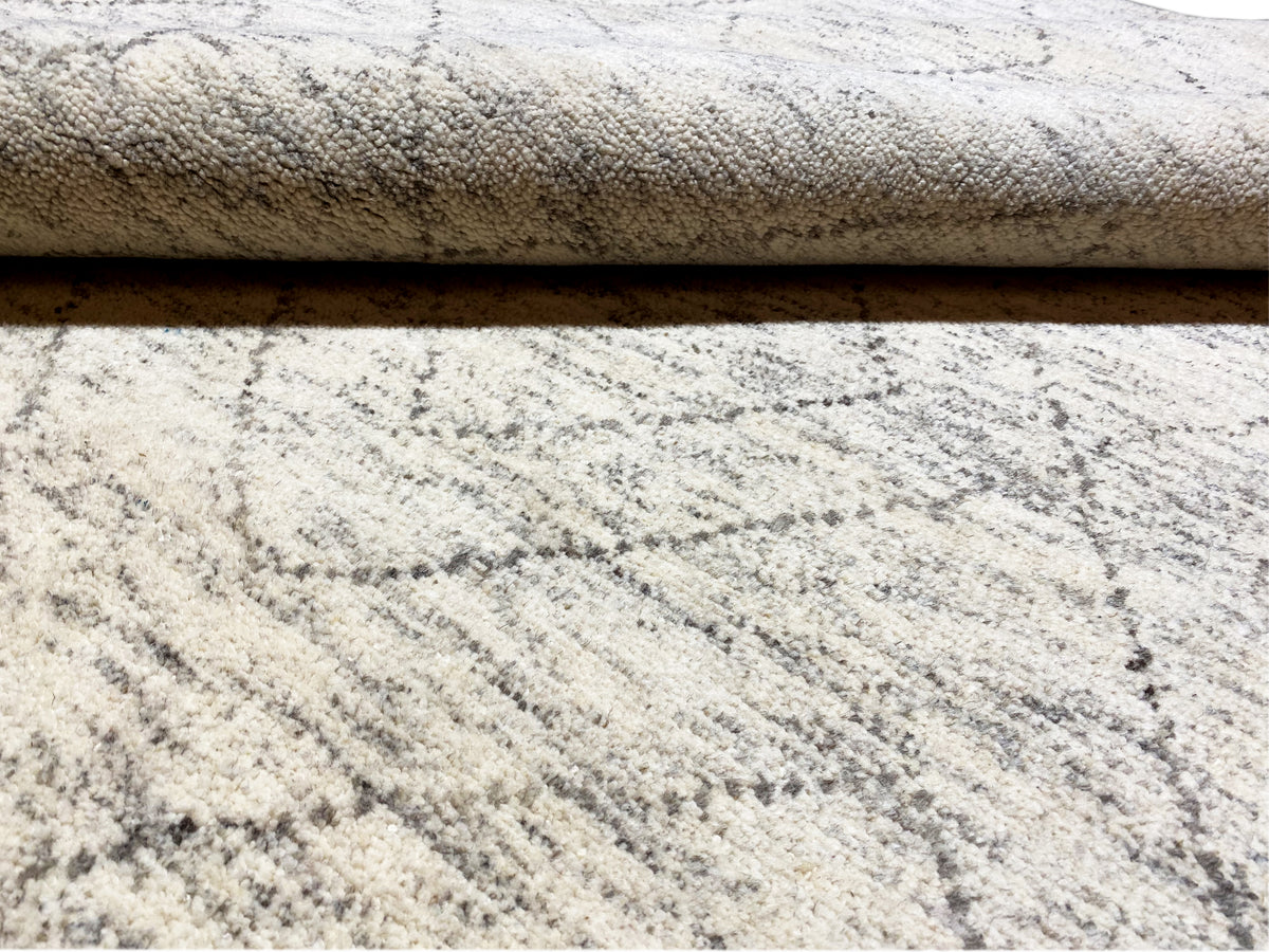 Tapis berbère : hauteur de poil et superposition visibles, beige clair avec un tracé de lignes gris