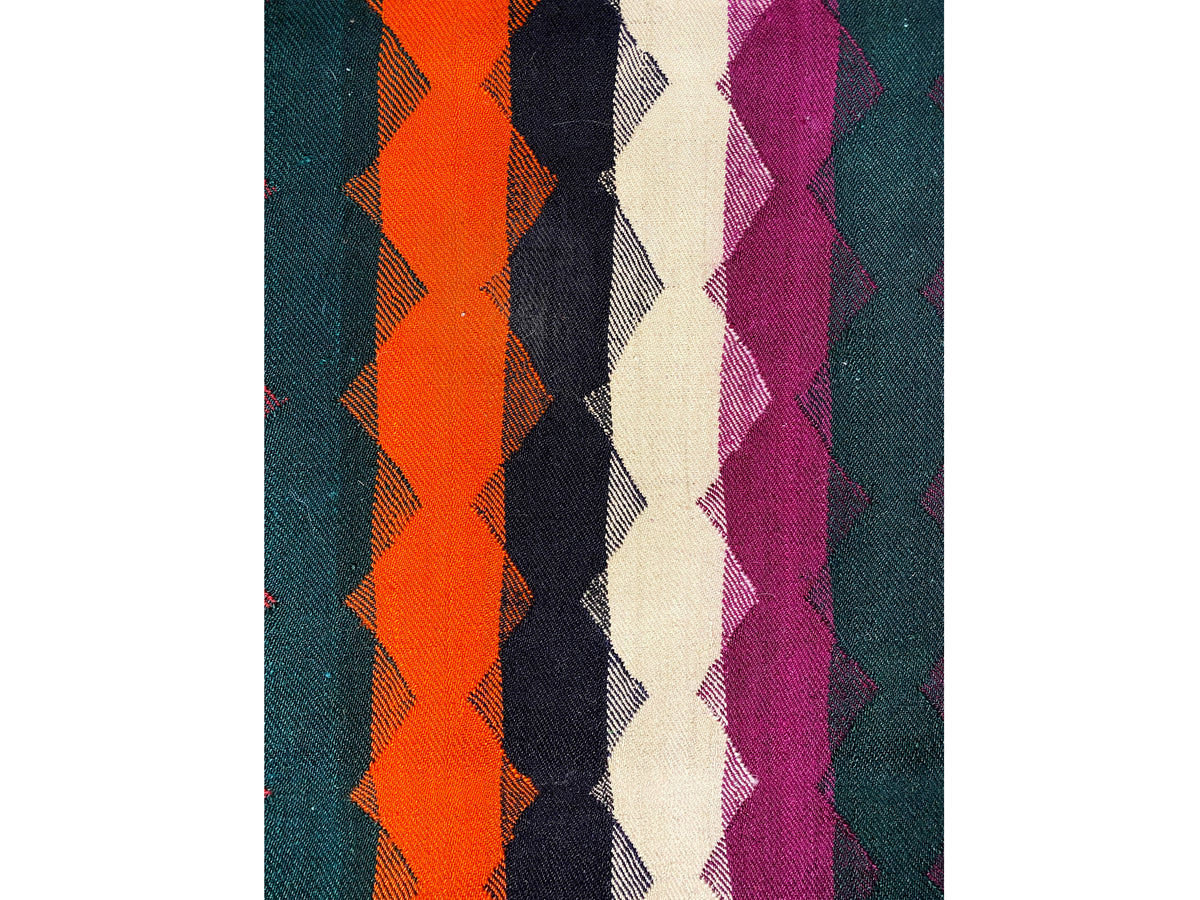 Gros plan : tapis jajim à motifs de losanges et de rayures orange, violets et bleu foncé