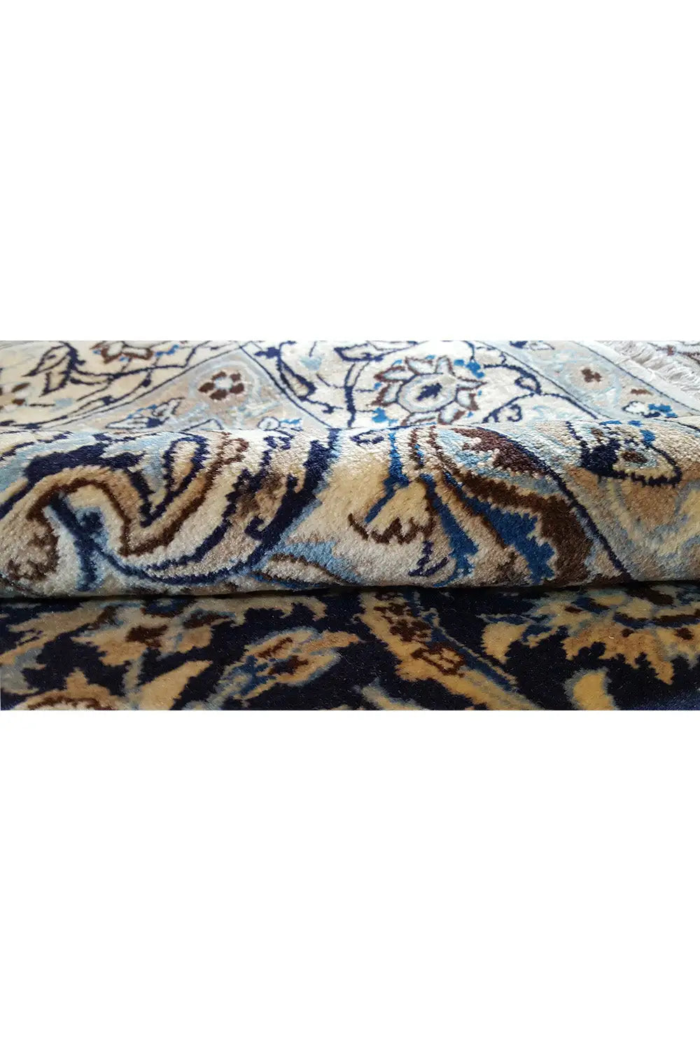 Vue détaillée : motif de tapis ornemental bleu et beige, avec une structure de velours visible.