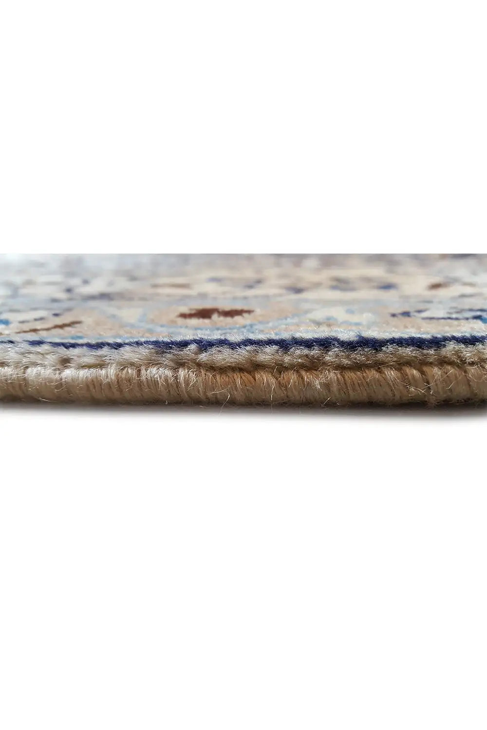 Gros plan du bord du tapis avec une bordure tissée et des poils visibles, légèrement effilochés.