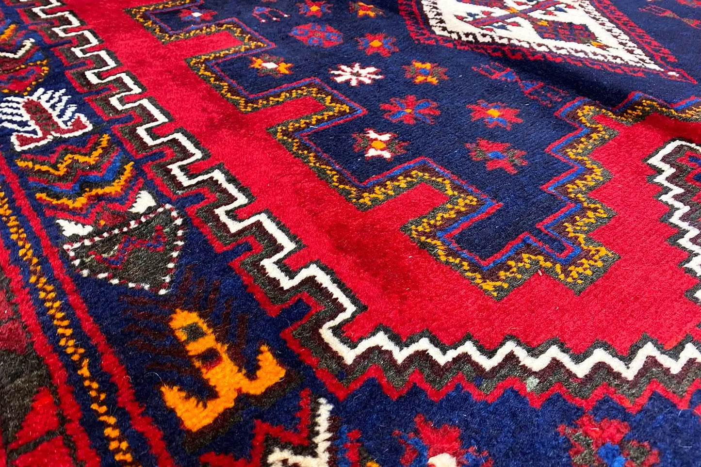 Surface de tapis avec une bande rouge, un motif en zigzag et des étoiles colorées