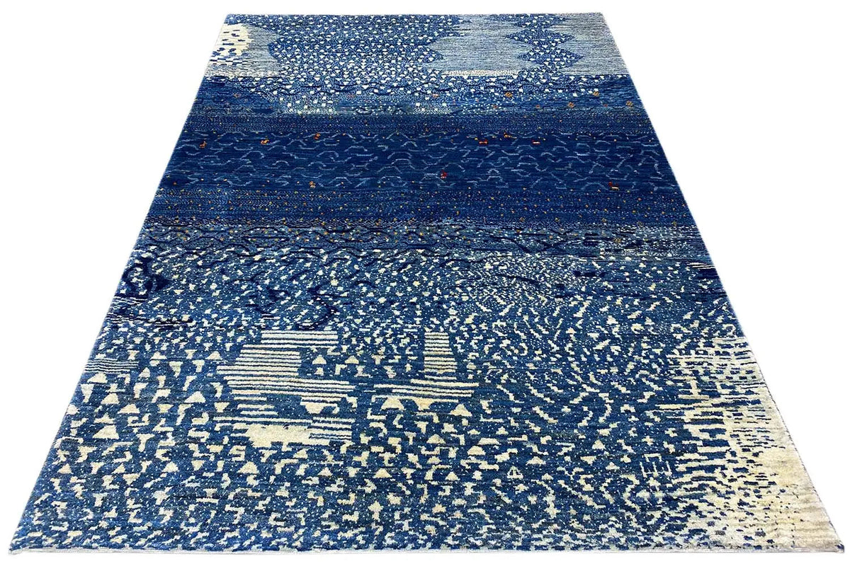 Tapis Gabbeh disposé en triangle avec agencement de bandes bleues et motif texturé clair