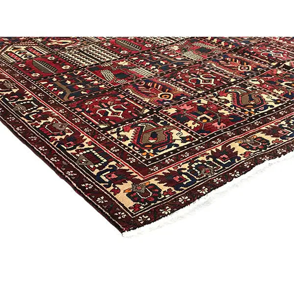 Vue détaillée d’un tapis oriental Bakhtiari : médaillons colorés, losanges et bordures dans des tons rouge foncé