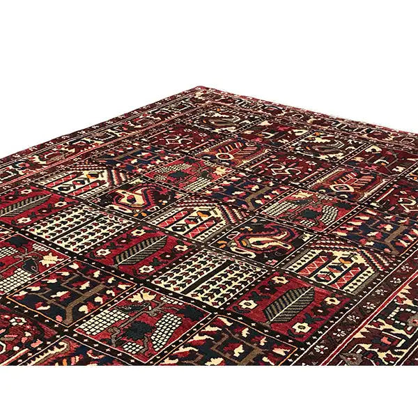 Tapis persan Bakhtiari vu en perspective oblique : champ central orné de motifs couleur bordeaux