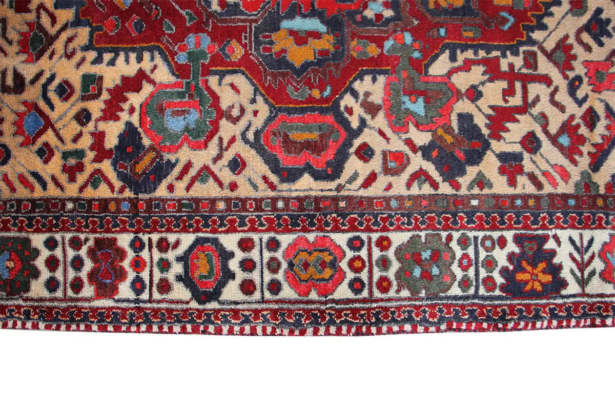 Bordure de tapis ornée de motifs rouges, bleus et beiges, avec une fine finition à franges