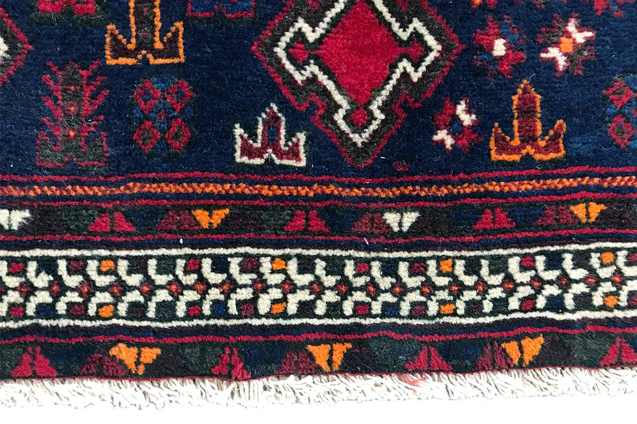 Bord de tapis avec de fines bordures décoratives, de petits symboles et des franges