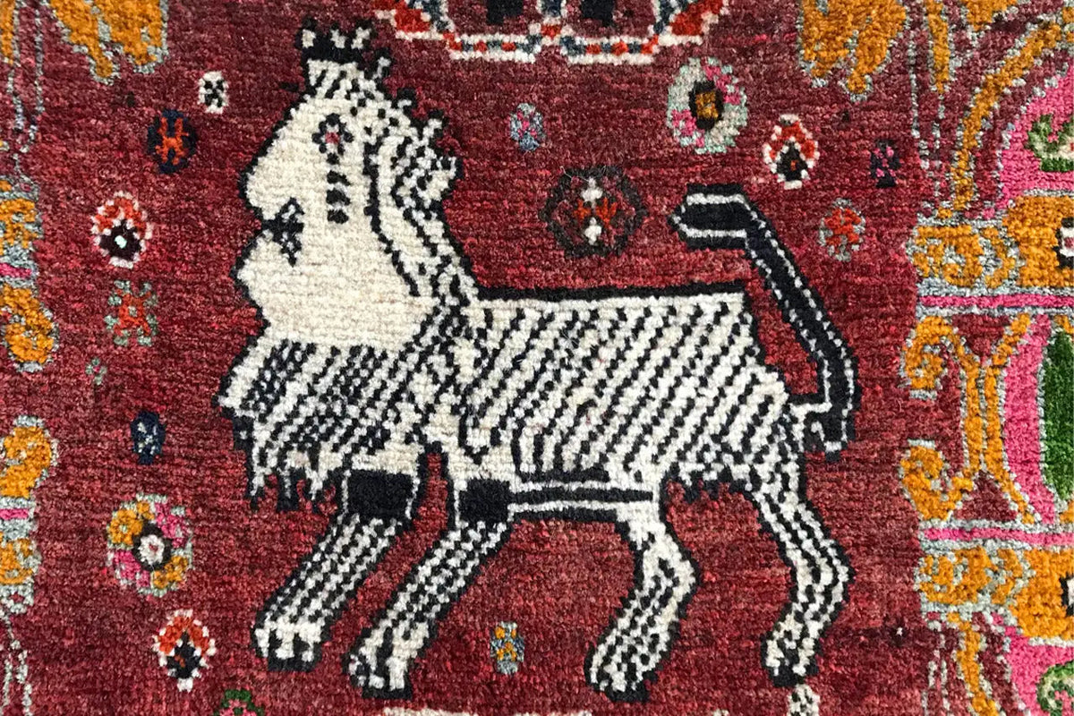 Détail du tapis : cheval blanc aux contours noirs sur fond rouge