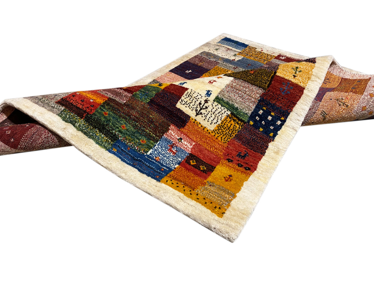 Tapis Gabbeh Luri 145x105 cm drapé en diagonale avec des blocs patchwork rouges, bleus et jaunes