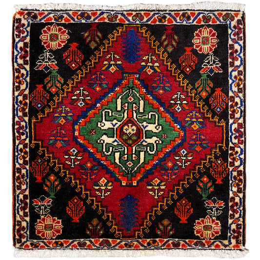 Tapis Poshti 56x56 cm à fond noir, ornements colorés et franges décoratives