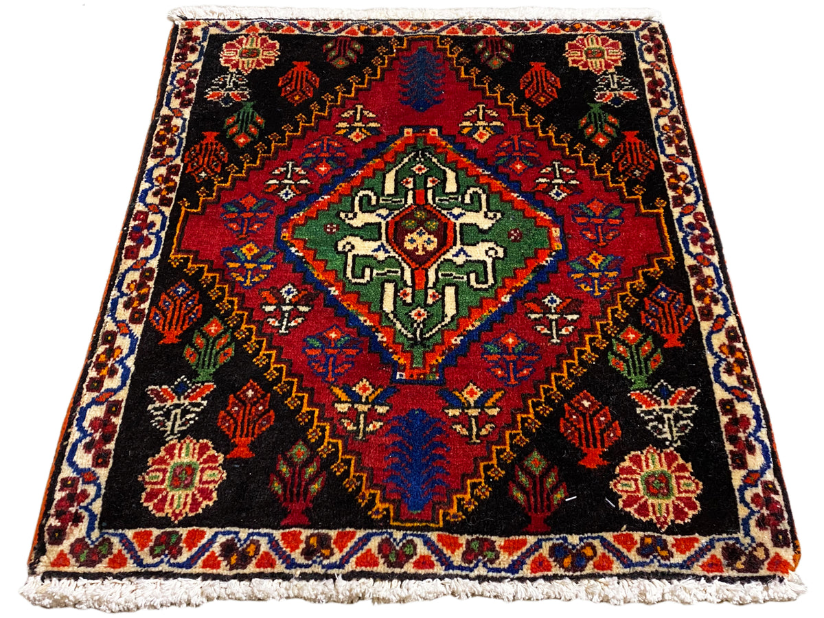Tapis Poshti 56x56 cm vu de dessus, fond noir avec motif de bordure rouge