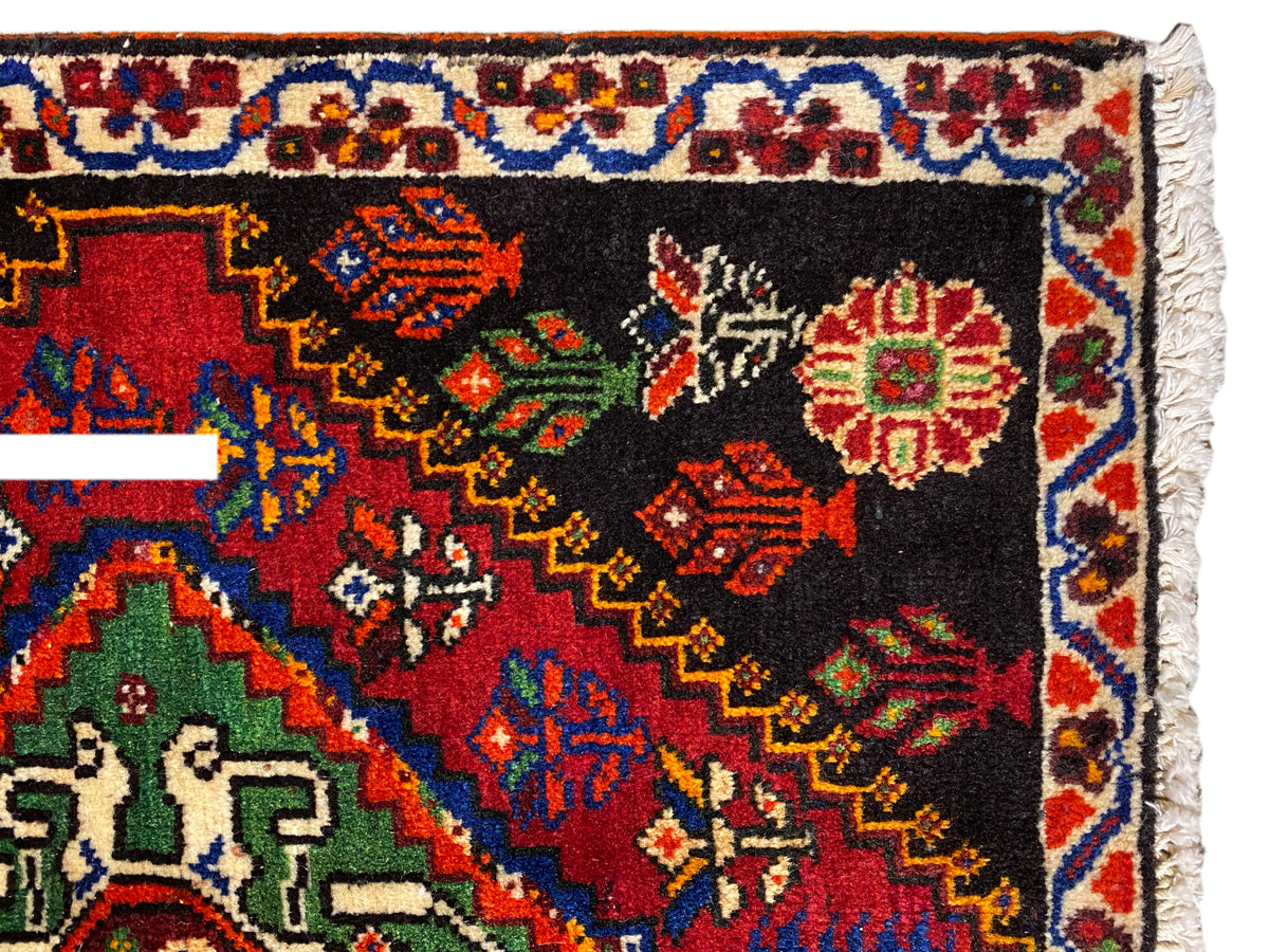 Tapis Poshti 56x56 cm, vue rapprochée : bordure ornementale avec des losanges colorés sur fond noir