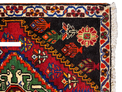 Tapis Poshti 56x56 cm, vue rapprochée : bordure ornementale avec des losanges colorés sur fond noir