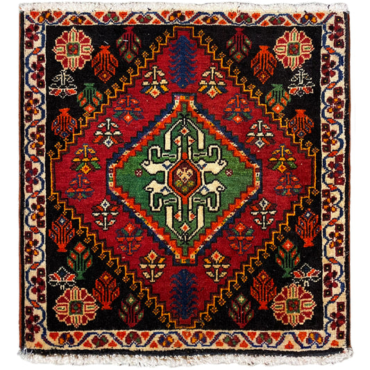 Tapis Poshti carré : tapis tissé noir avec motif décoratif rouge, vert et bleu