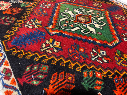 Vue détaillée d’un coin de tapis Poshti : ornements géométriques multicolores sur fond noir