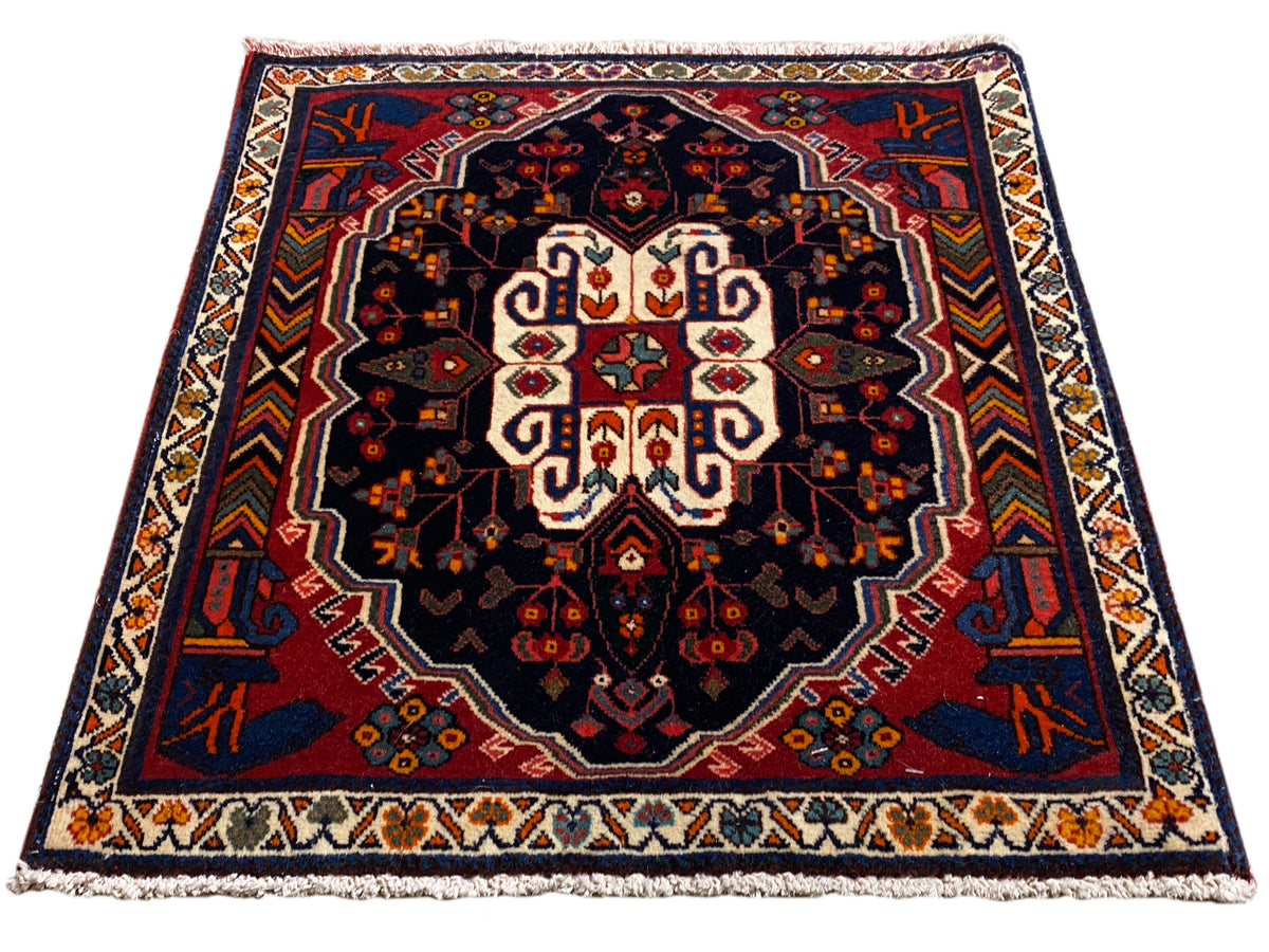 Tapis Poshti rectangulaire à fond bleu avec un motif ornemental symétrique
