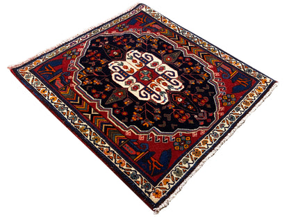 Tapis Poshti à motif losanges, fond sombre et ornement central blanc