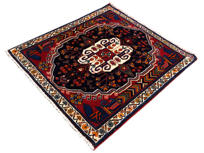 Tapis Poshti carré avec motif sombre, accents rouges et médaillon blanc