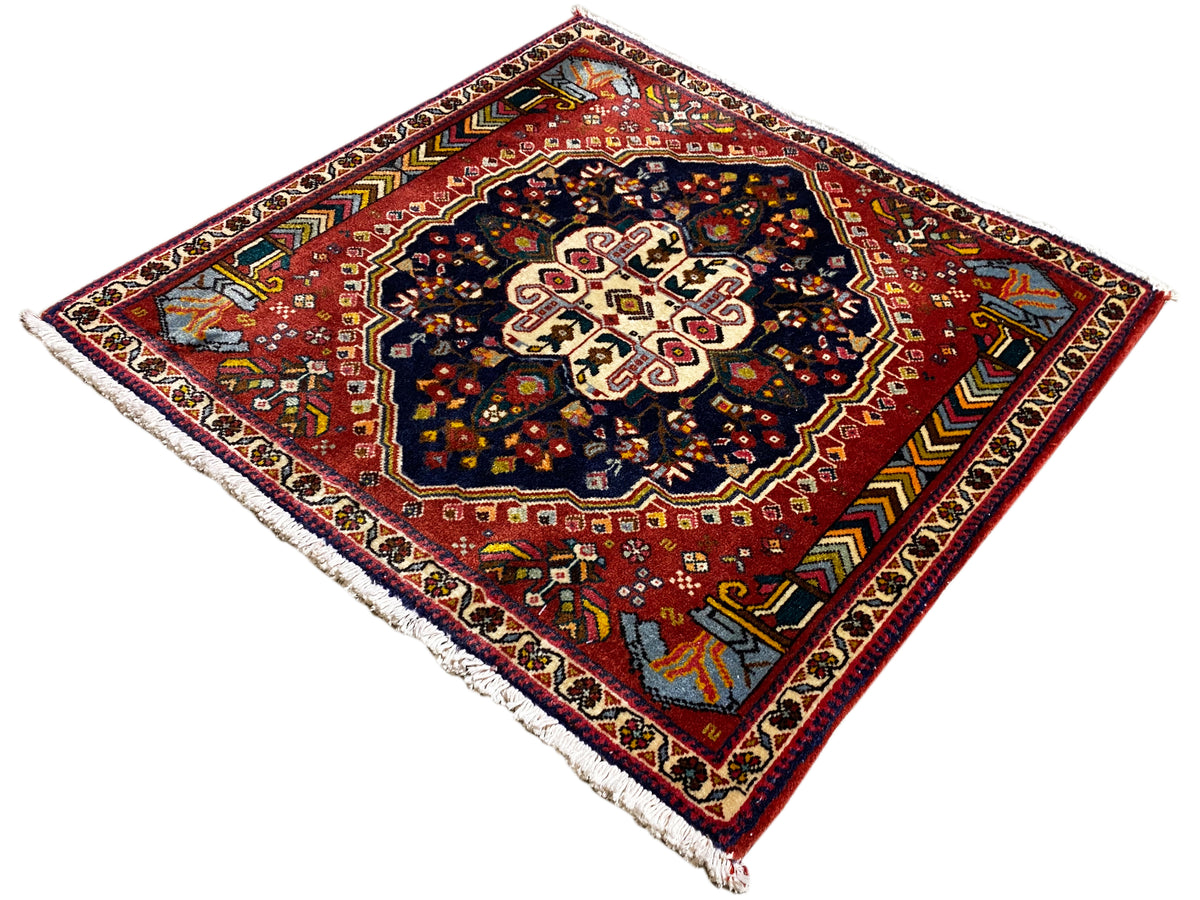 Tapis Poshti à fond rouge, médaillon sombre et bordure périphérique multicolore