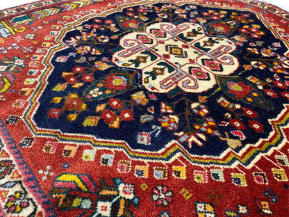 Détail du tapis Poshti : motif central en croix avec des ornements décoratifs colorés