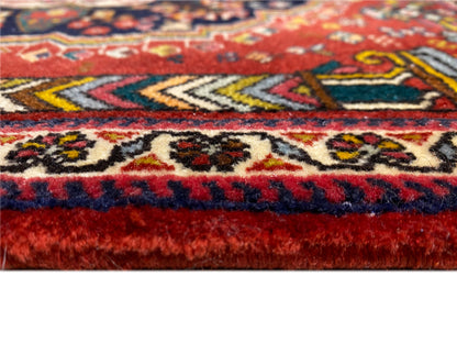 Détail de la bordure du tapis Poshti avec des franges rouges et bleues et des motifs tissés