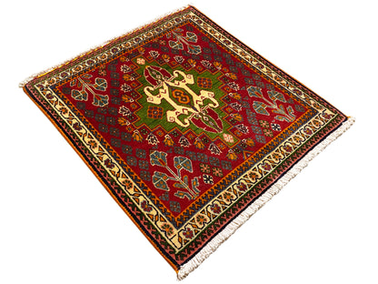 Tapis oriental rouge orné de motifs en croix et de rinceaux, avec des accents verts et une bordure décorative