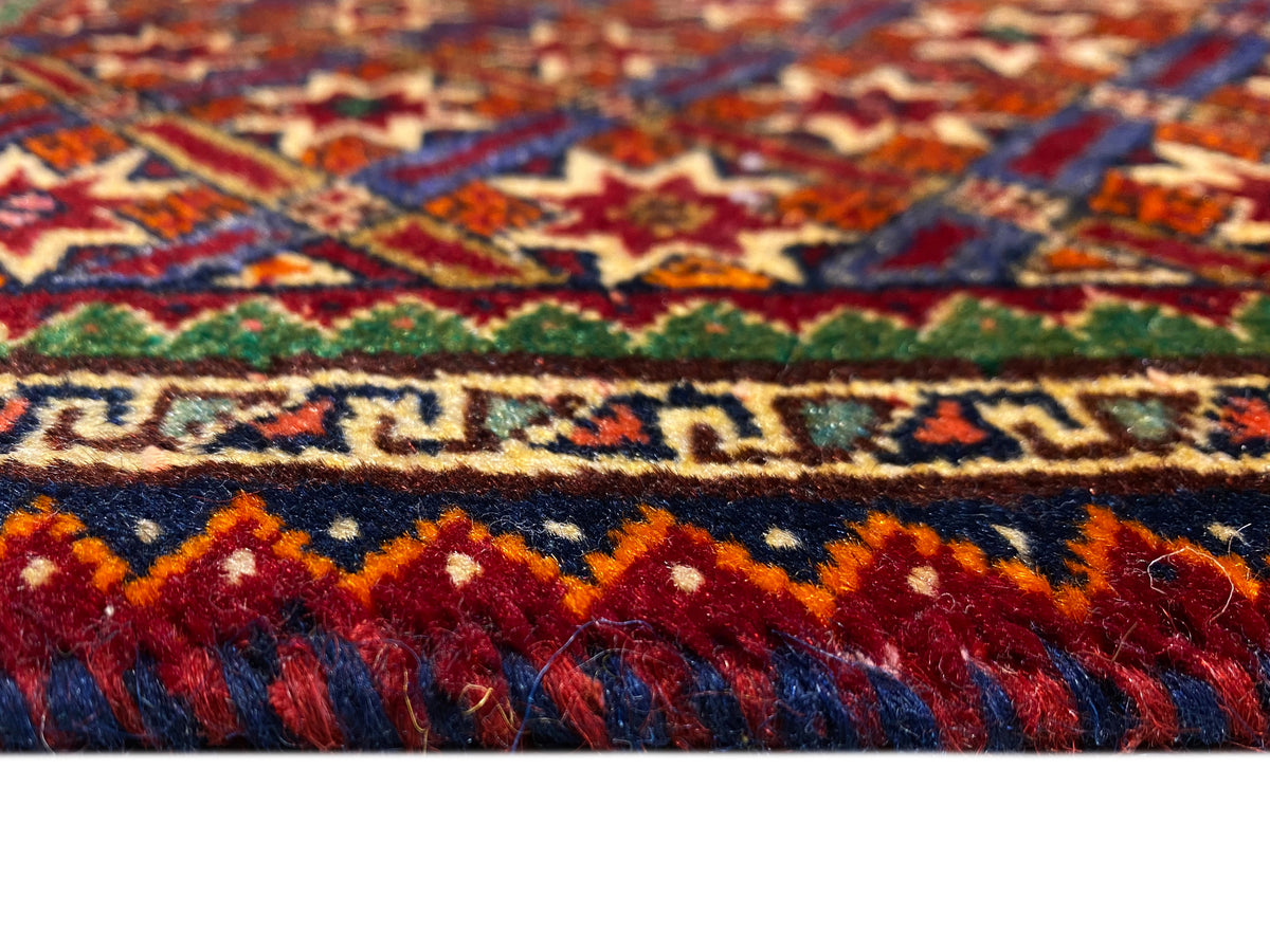 Tapis Poshti 62x52 cm en gros plan : bandes colorées et franges à poils longs.