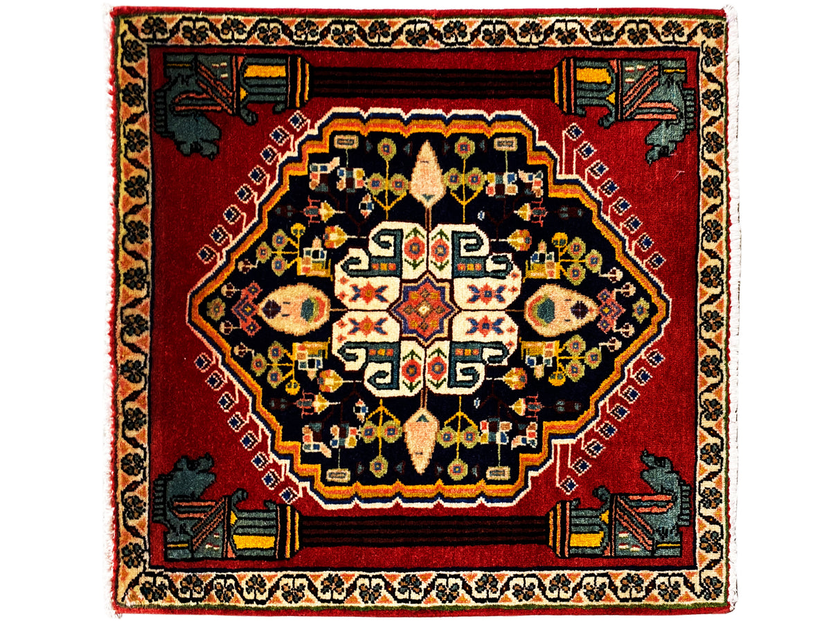 Tapis Poshti à fond rouge, médaillon sombre et motifs colorés au centre