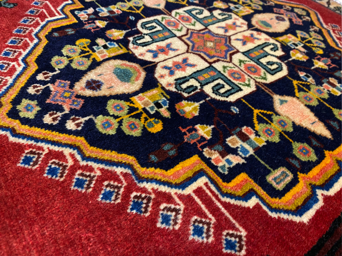 Tapis Poshti à centre bleu foncé, bordures rouges et motifs géométriques colorés