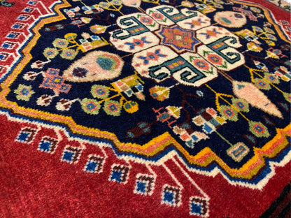 Tapis Poshti à centre bleu foncé, bordures rouges et motifs géométriques colorés