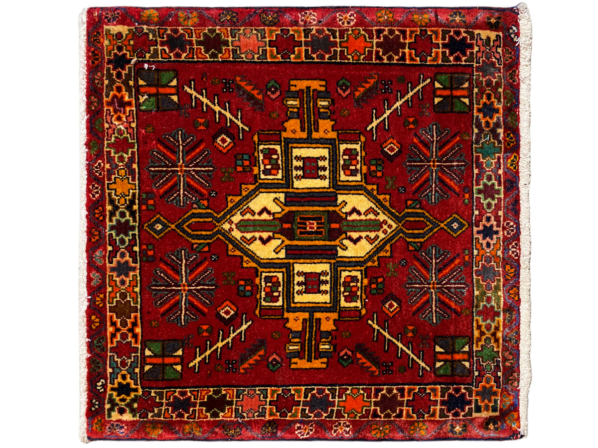 Tapis Poshti rectangulaire à fond rouge et motif central géométrique multicolore