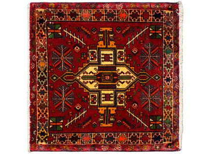 Tapis Poshti rectangulaire à fond rouge et motif central géométrique multicolore