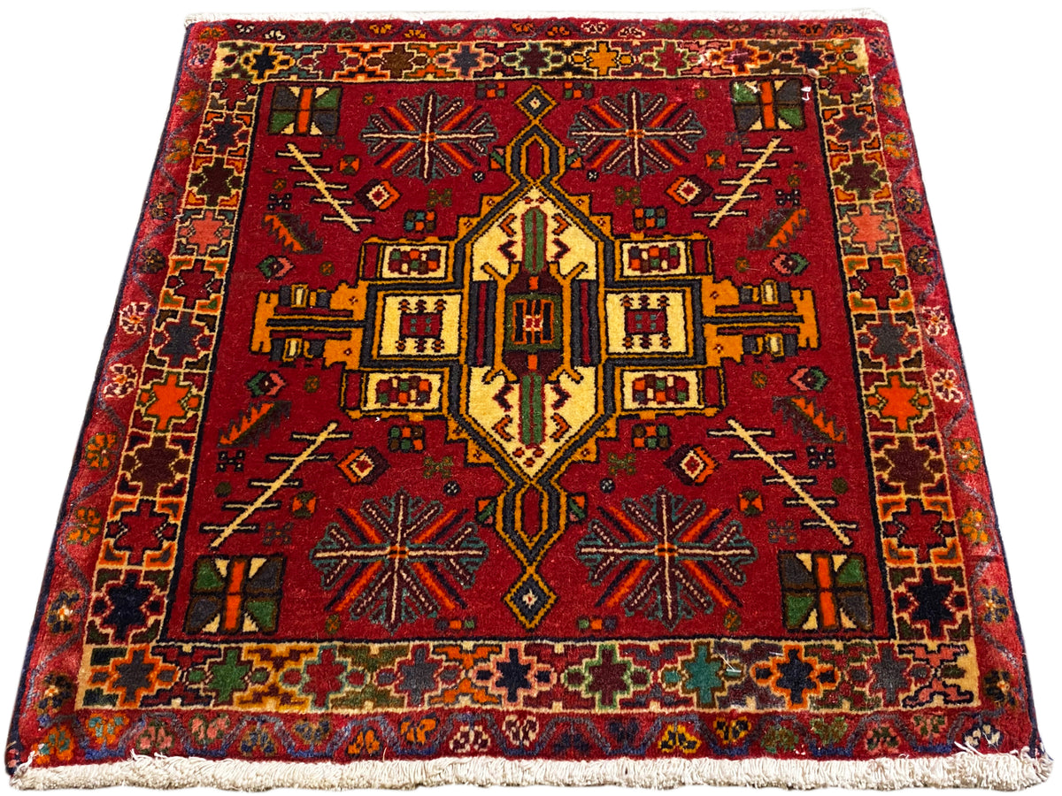 Tapis Poshti rouge avec motif central symétrique et bordure multicolore