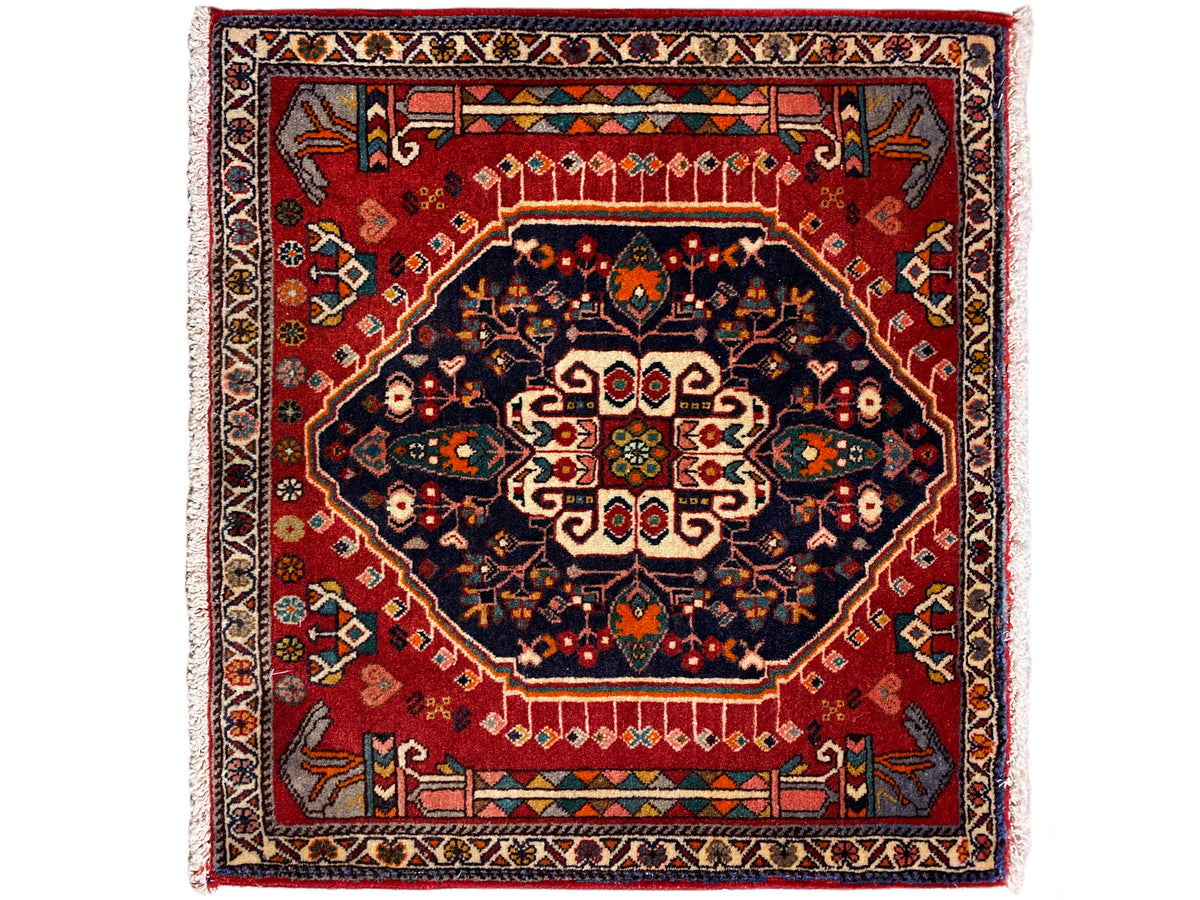 Tapis à fond rouge, médaillon bleu foncé et bordure multicolore, carré