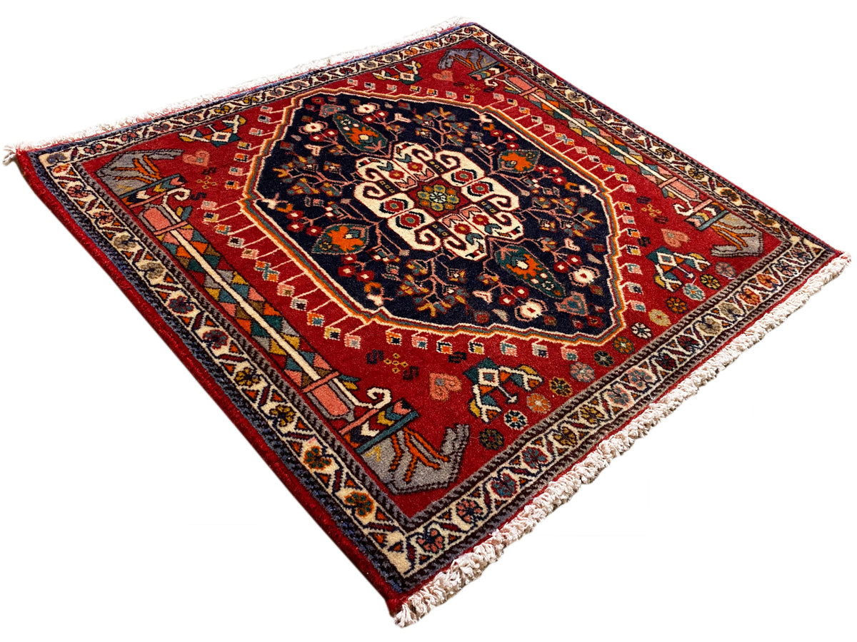 Tapis à fond rouge et motif ornemental bleu, rectangulaire, avec franges