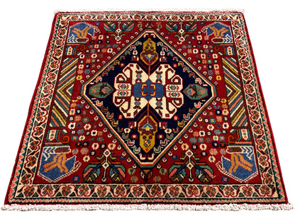 Tapis 66x62 cm avec motif rouge, cadre sombre et ornements colorés