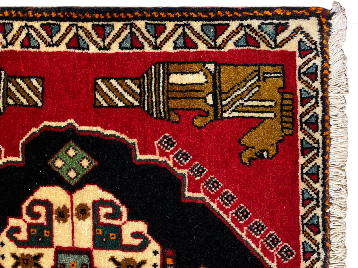 Tapis Poshti 63x55 cm : détail de la bordure avec franges et bande ornementale multicolore sur fond rouge