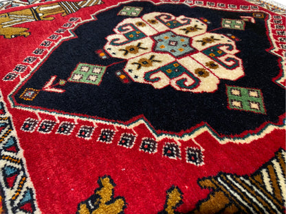 Tapis Poshti 63x55 cm : gros plan sur le médaillon central aux motifs rouges et noirs