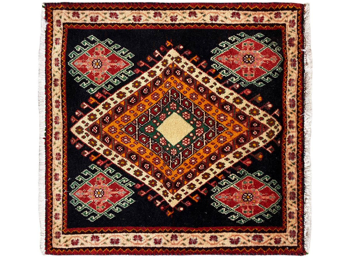 Tapis Poshti à fond noir, avec un losange orange-jaune et quatre médaillons verts et rouges