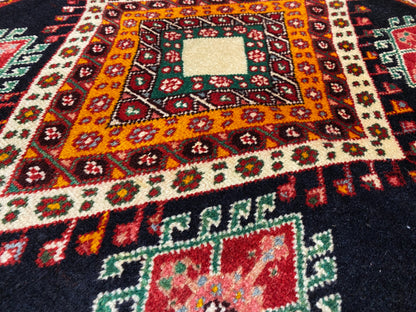 Vue détaillée d’un tapis Poshti avec un losange central orange-jaune, de petits éléments ornementaux et un centre blanc